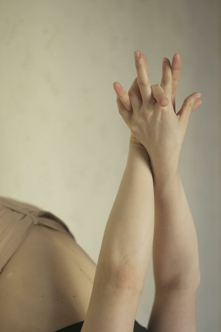 Hands intertwined in a yoga pose symbolizing flexibility and mindfulness.